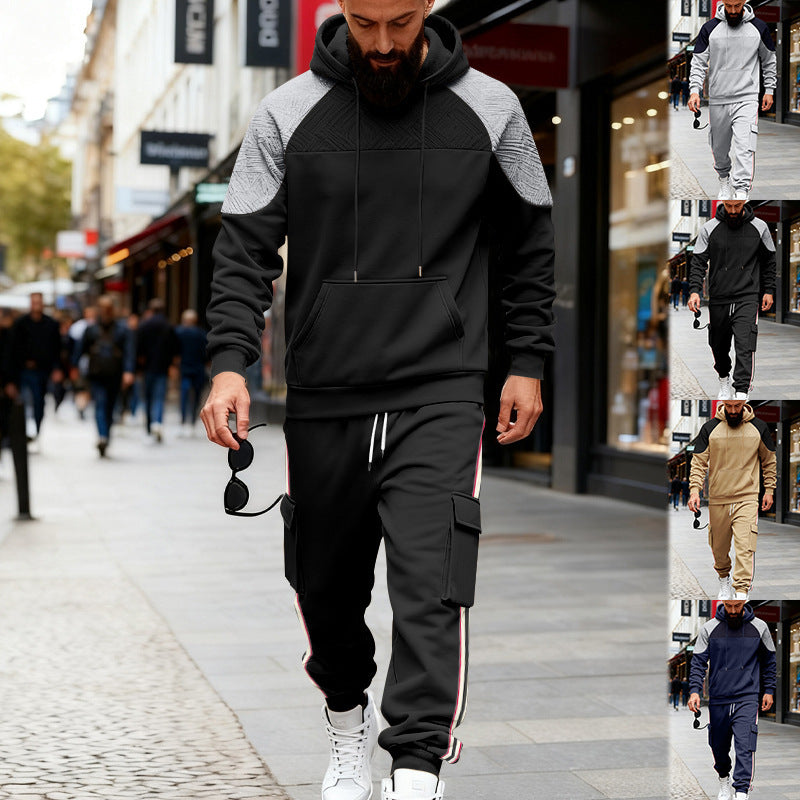 Man walking in black and gray color-block hoodie and black cargo sweatpants with side stripes on city street