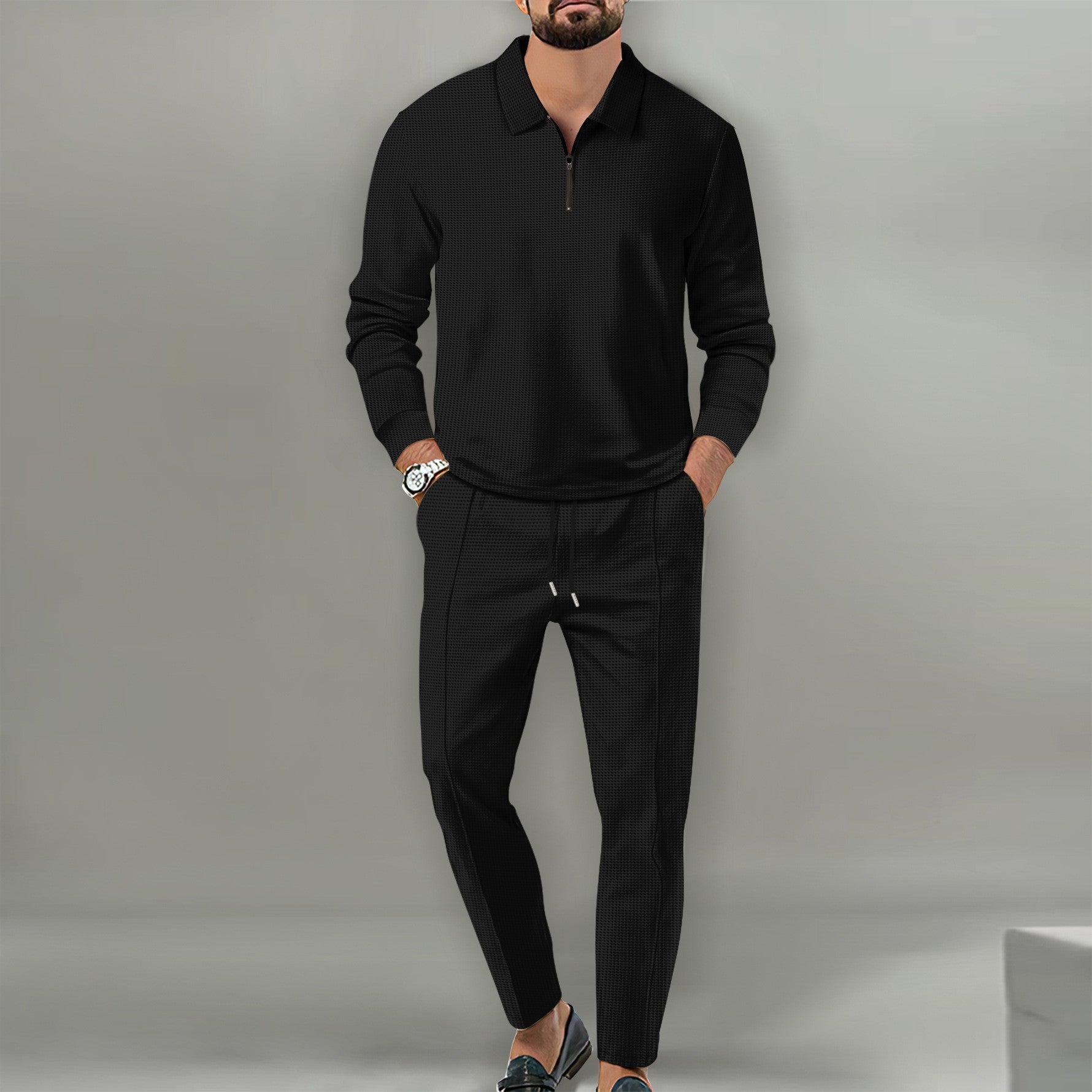 Man wearing black waffle knit cotton blend long sleeve zipper top and matching black slim trousers outfit