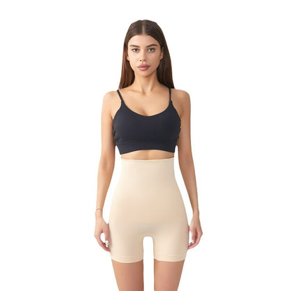 Woman wearing beige high-waist shaping shorts and black sports bra on white background