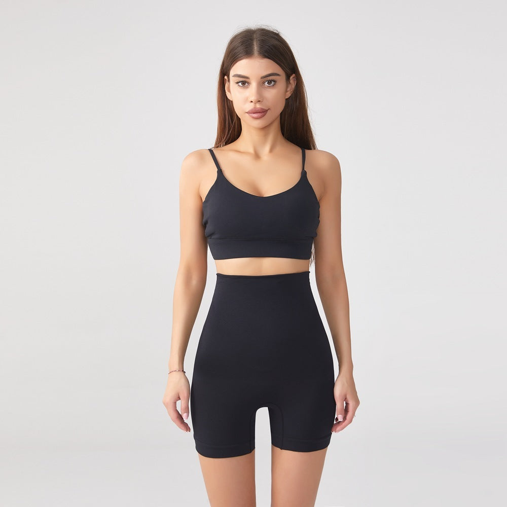 Woman wearing black seamless high waist shaping shorts and sports bra on gray background