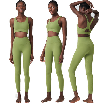 Woman modeling olive green high-waist leggings and sports bra with butterfly back design, studio white background