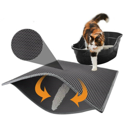 Calico cat stepping out of black litter box onto black honeycomb cat litter mat with textured surface