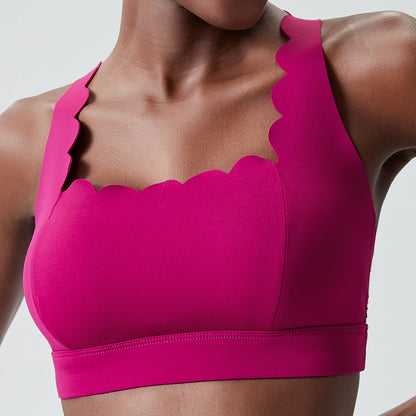 Close-up of woman wearing magenta sports bra with scalloped edges and thick straps