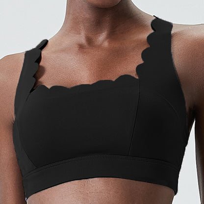 Close-up of a woman wearing a black plus-size sports bra with scalloped edges