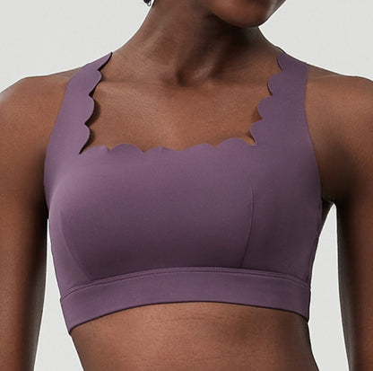 Close-up of woman wearing purple scalloped edge sports bra, fitness activewear top