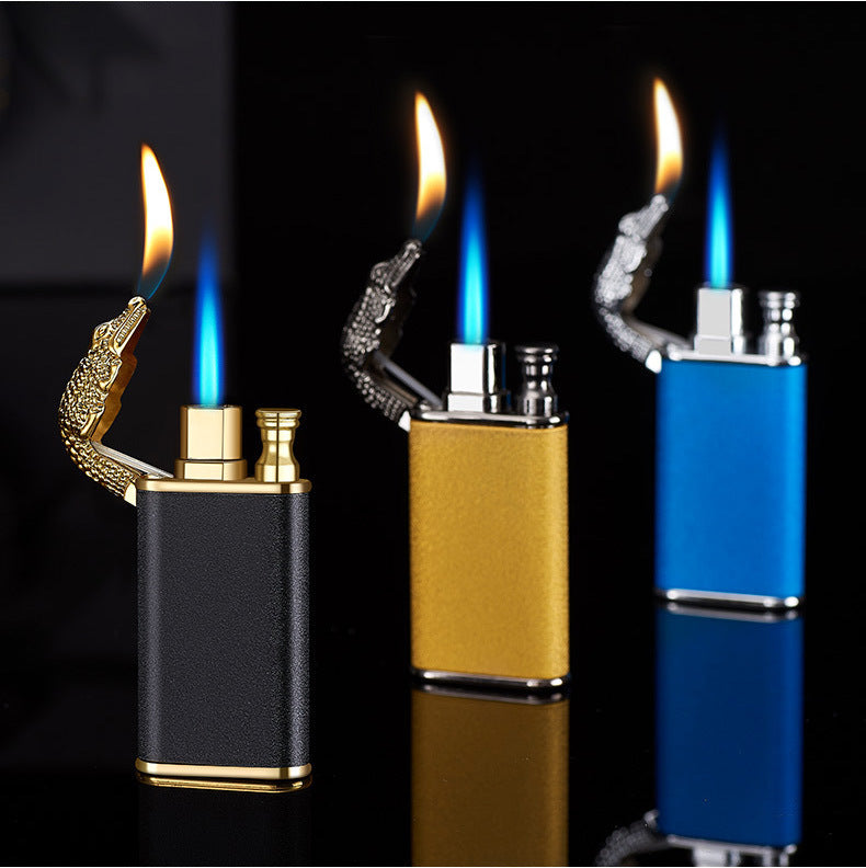 Three double flame windproof metal lighters with crocodile-shaped open caps in black, gold, and blue on black surface