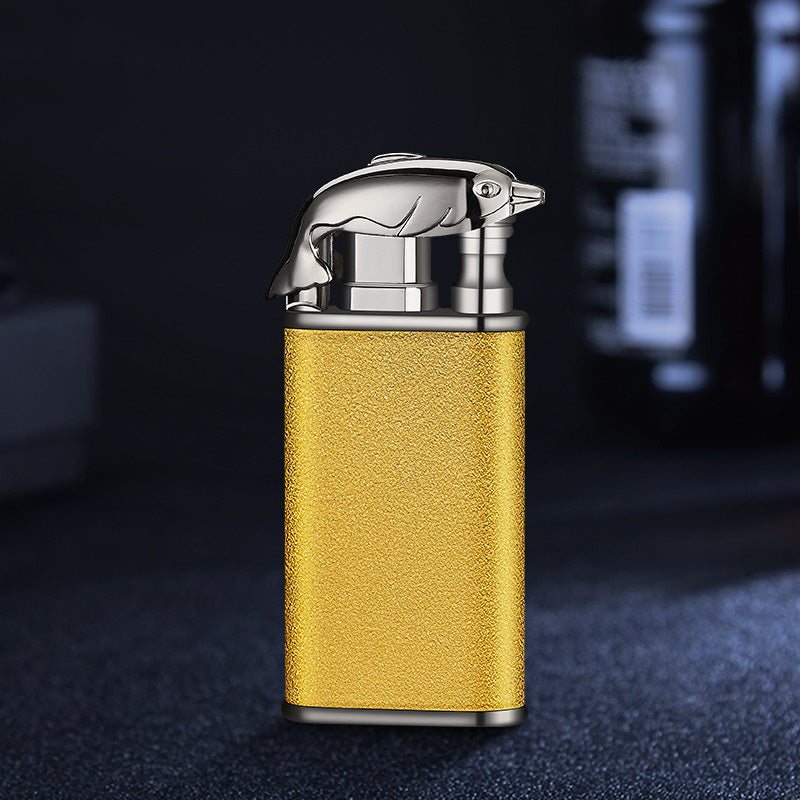 Gold textured metal windproof cigar lighter with silver crocodile-shaped top on dark background