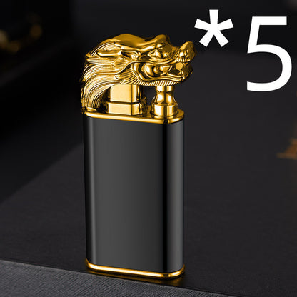 Black metal cigar lighter with gold dragon head design on top, standing on dark surface