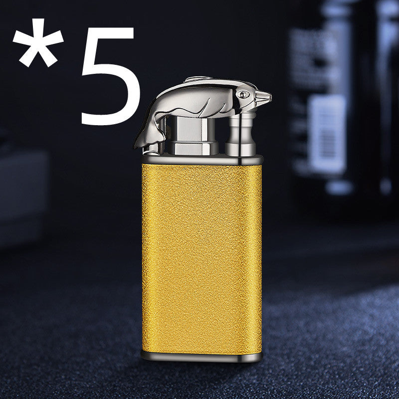 Golden metal cigar lighter with silver crocodile-shaped top on dark background