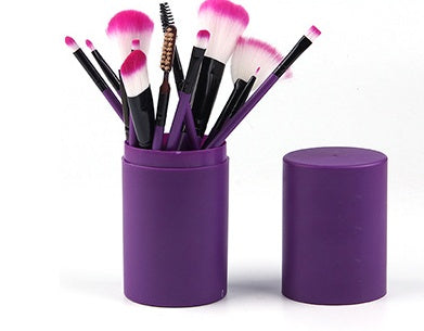 12-piece purple makeup brush set with soft pink and white bristles in matching purple holder