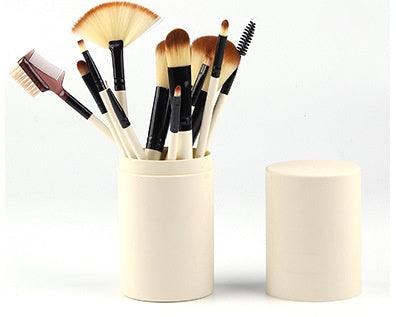 12-piece black cosmetic makeup brush set with soft bristles in beige holder on white background