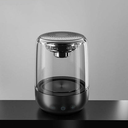 Transparent portable Bluetooth speaker with visible speaker driver and black base with control buttons