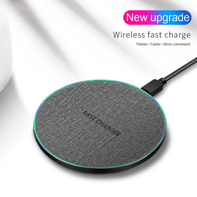 Ultra-thin gray fabric wireless fast charger with LED edge and USB cable on white surface