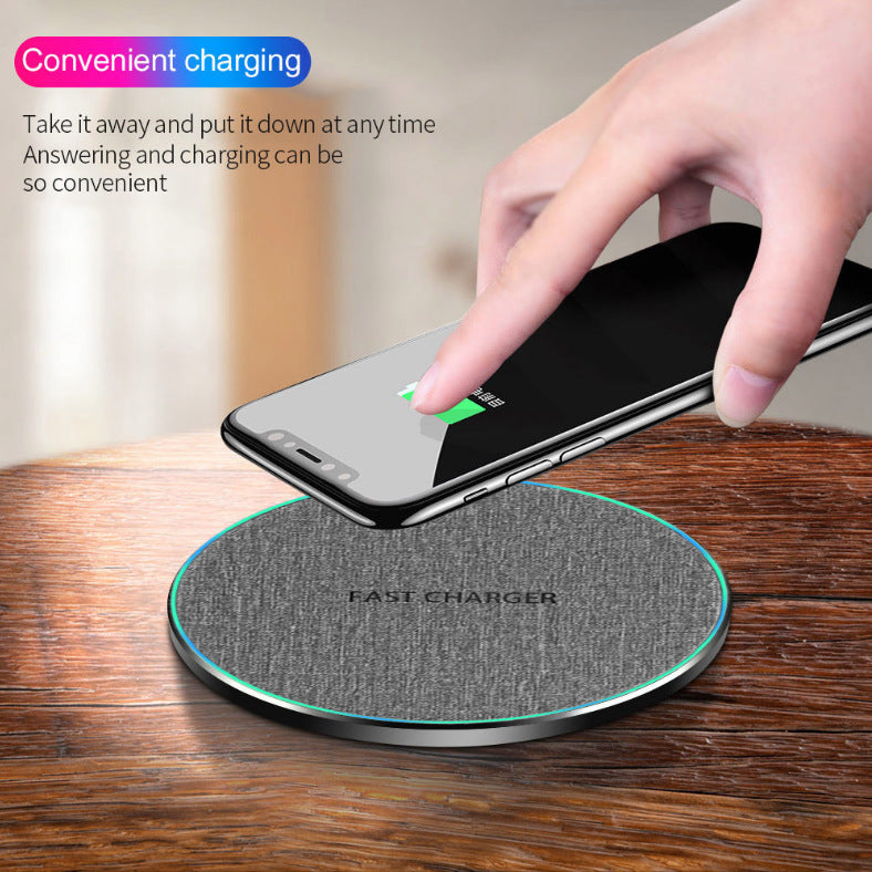 Hand placing smartphone on gray fabric wireless fast charger on wooden surface with text about convenient charging