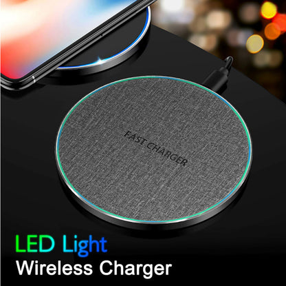 Ultra-thin fabric and aluminum alloy wireless fast charger with LED light on black surface charging smartphone