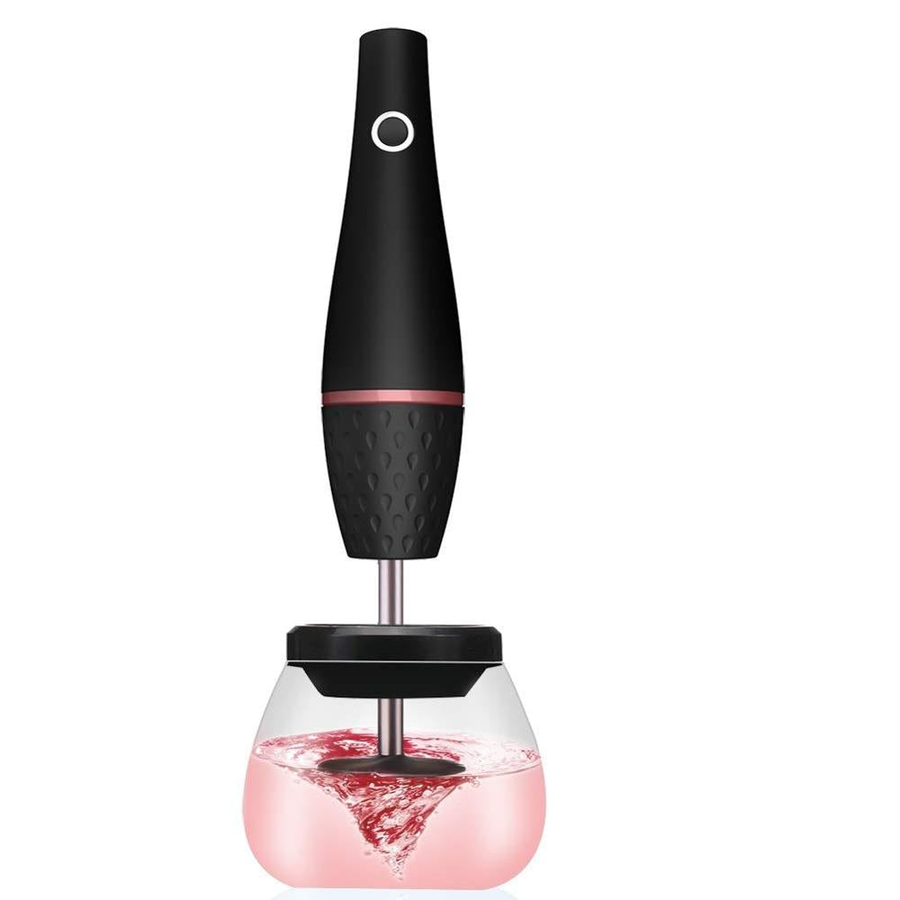 Black electric makeup brush cleaner with clear cup and swirling pink liquid