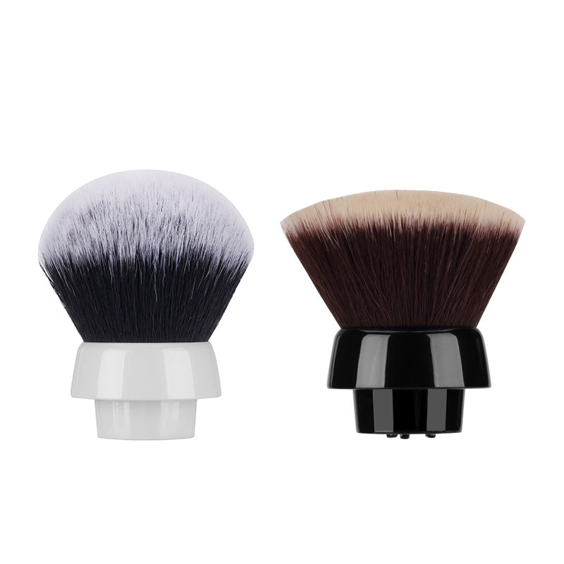 Two detachable makeup brush heads with synthetic bristles, one with white and black bristles and white base, the other with brown and beige bristles and black base