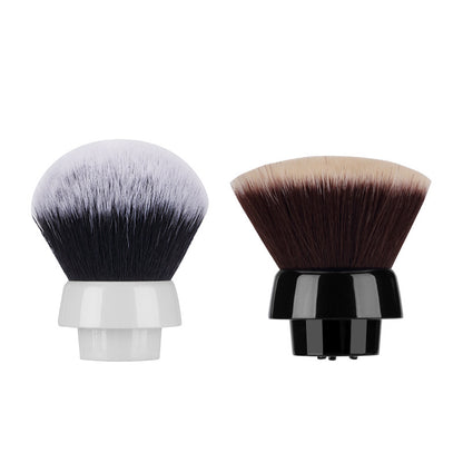 Two detachable makeup brush heads with synthetic bristles, one with white and black bristles and white base, the other with brown and beige bristles and black base