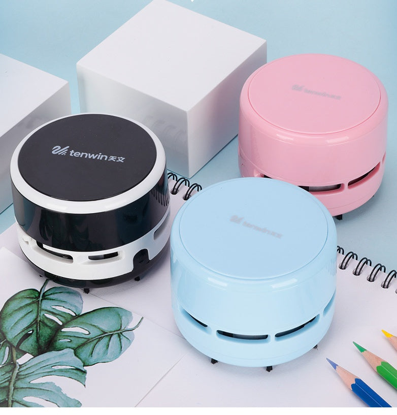 Three compact tenwin mini electric desktop vacuum cleaners in black, pink, and blue on a light blue surface