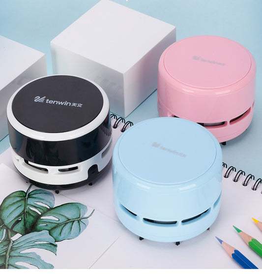 Three compact tenwin mini electric desktop vacuum cleaners in black, pink, and blue on a light blue surface