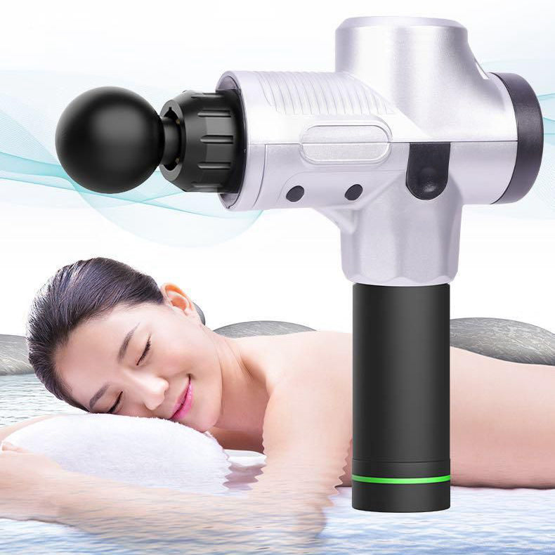 Silver and black deep tissue percussion massage gun with woman relaxing on towel in spa setting