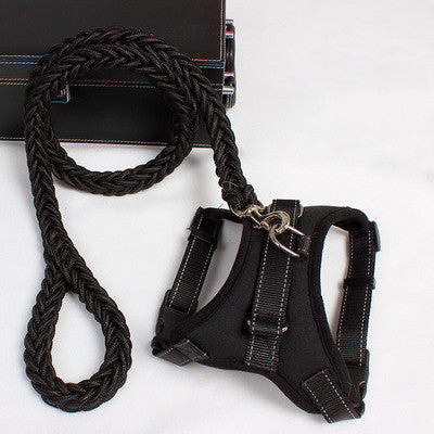 Black adjustable nylon dog harness with reflective stitching and braided leash on white surface