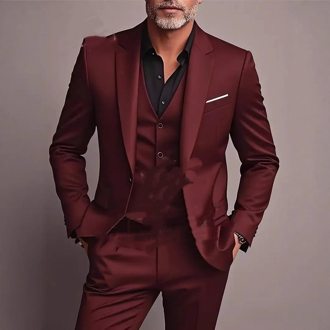 Man wearing a slim-fit dark red three-piece suit with a black shirt and white pocket square