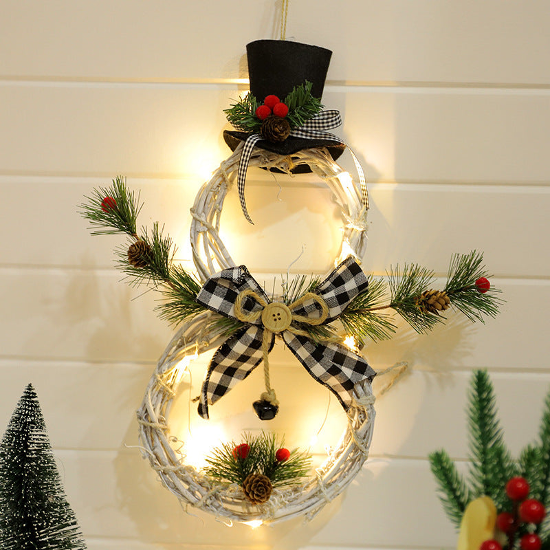 LED Christmas wreath shaped like a snowman with black top hat, pine cones, berries, and gingham bow