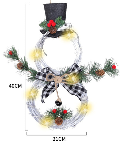 Battery-operated LED Christmas wreath shaped like a snowman with black top hat, pine cones, red berries, and plaid bow