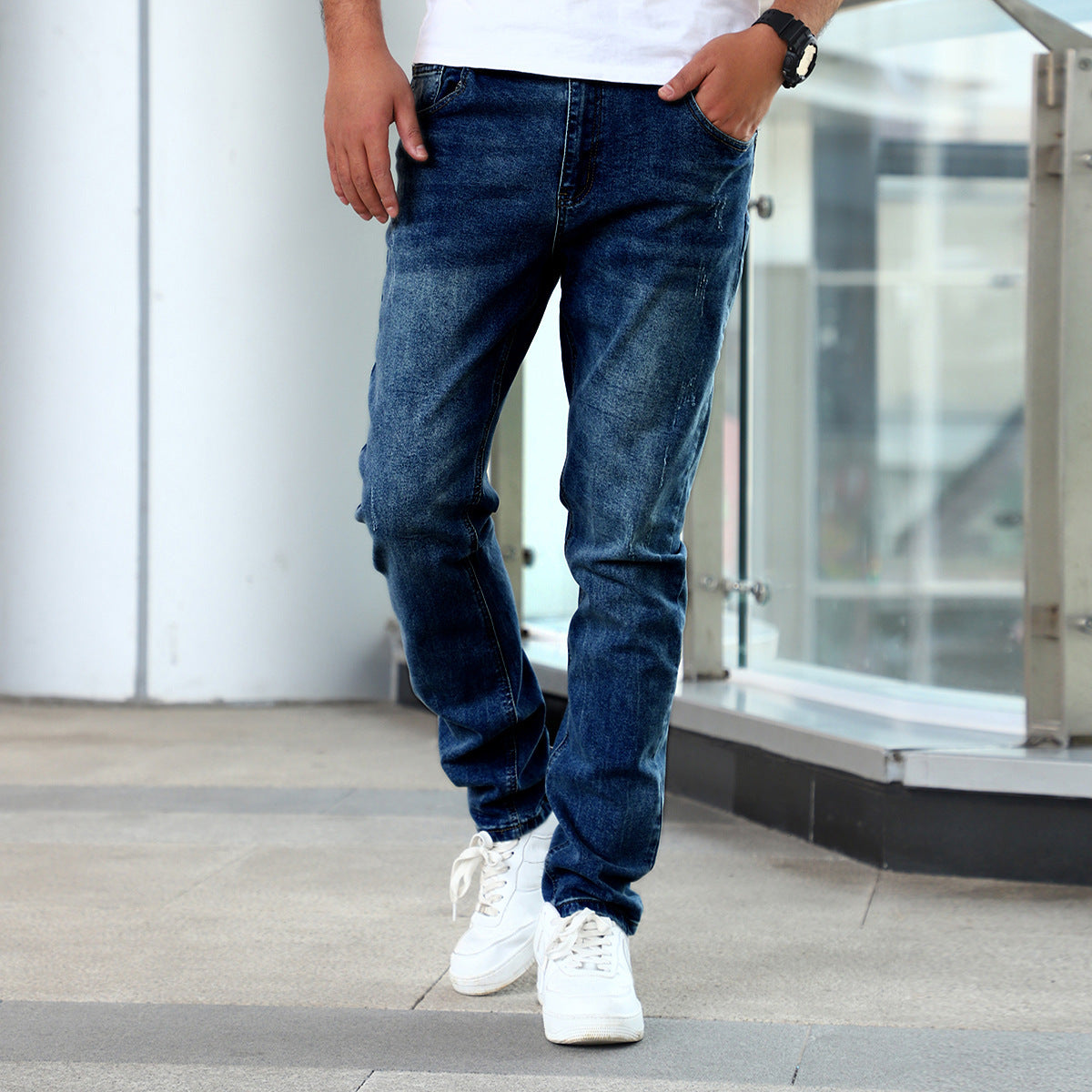 Man wearing blue slim fit stretch denim jeans with casual white sneakers