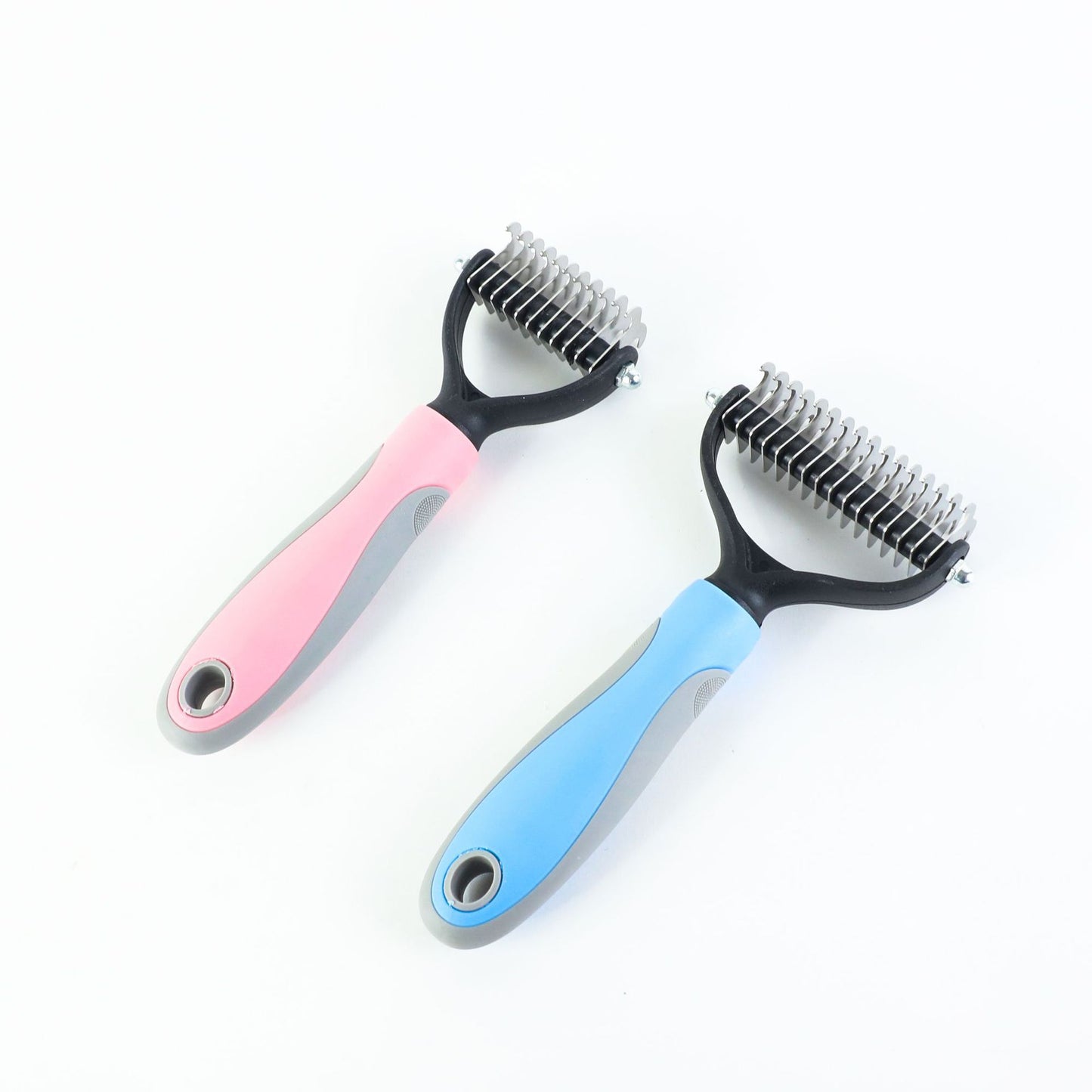 Two double-sided pet deshedding combs with blue and pink ergonomic grips on white background