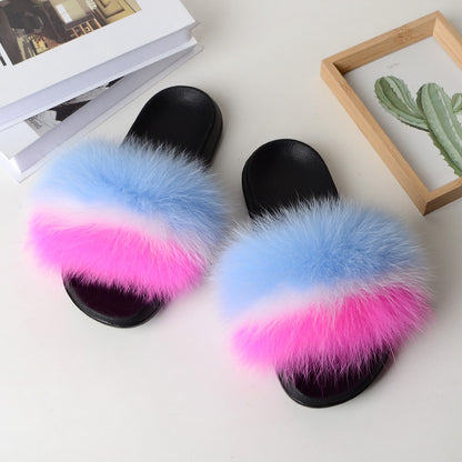 Black open-toe sandals with blue, white, and pink fox fur straps on white surface