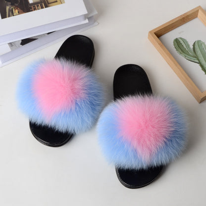 Black open-toe sandals with pink and blue fluffy fox fur straps on white surface