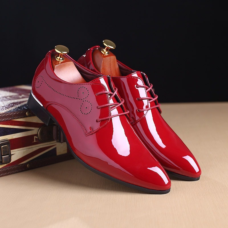 Shiny red men's leather dress shoes with lace-up design, wooden shoe trees, and decorative stitching
