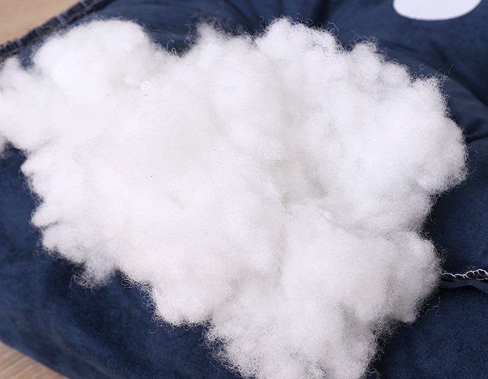 Soft white PP cotton filling on a blue plush pet bed for cozy comfort