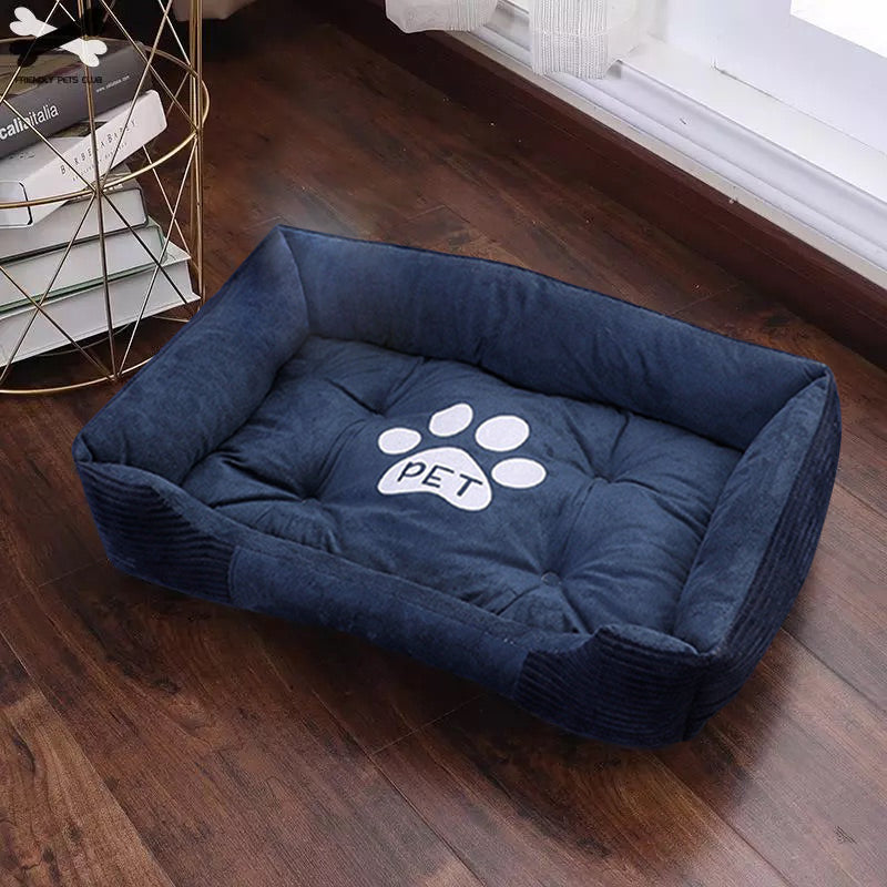 Blue soft plush pet bed with white paw print and PET text on wooden floor