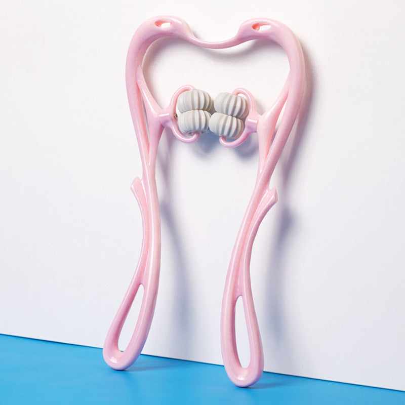 Pink dual-handle neck massager with four white textured rollers, standing against white wall on blue floor