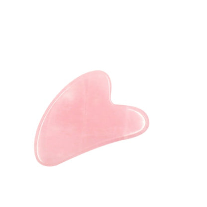 Pink gua sha tool for facial massage and skincare on white background