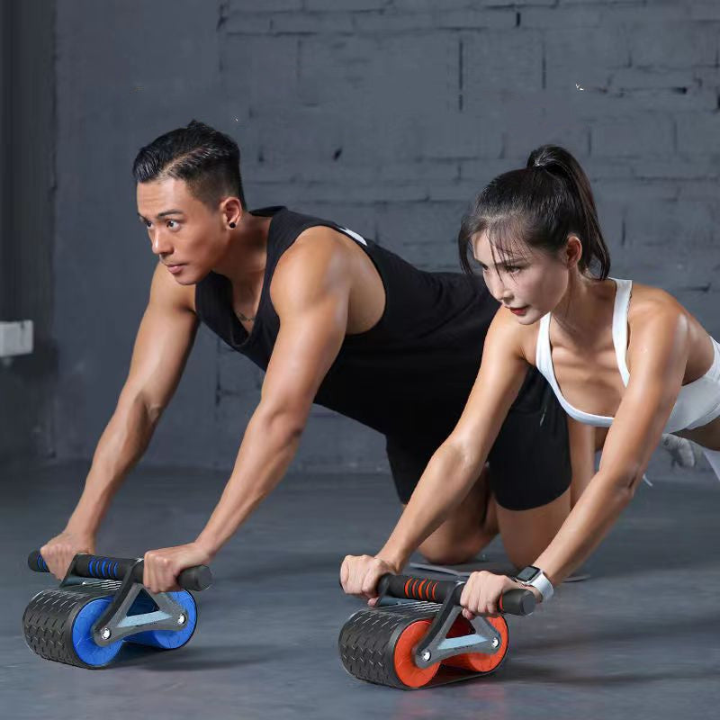 Fit man and woman using blue and red ab roller wheels for core training in home gym