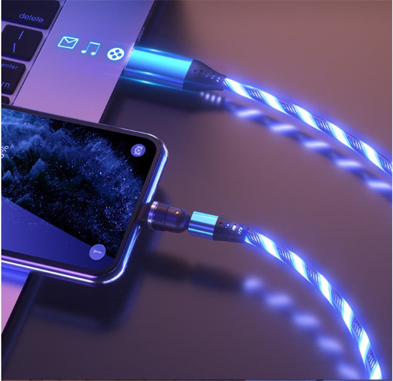 Blue luminous magnetic charging cables connected to a smartphone and laptop on dark surface