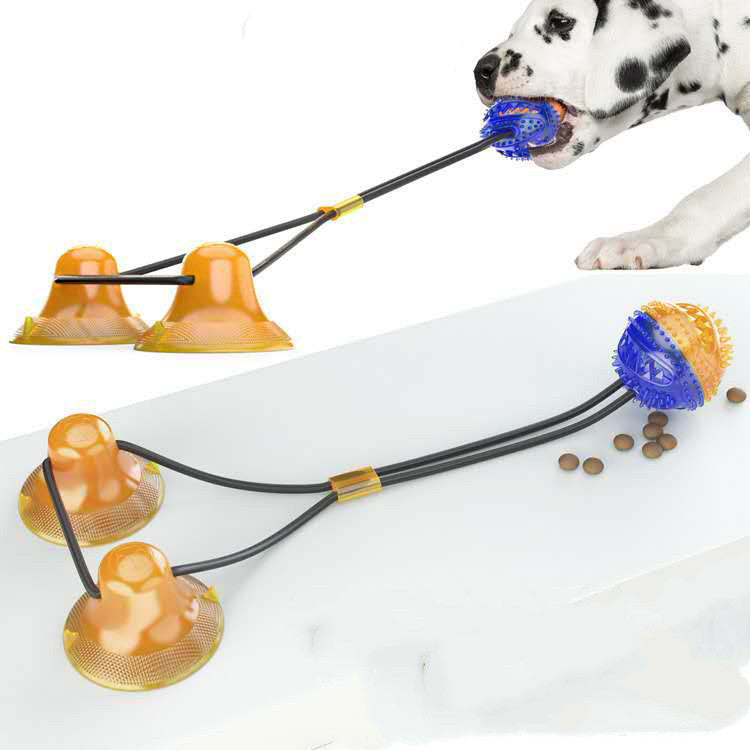 Blue and orange interactive dog toy with suction cups and a tug rope, held by a white dog with black spots