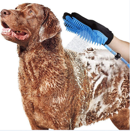 Hand wearing black glove using blue pet shower brush with water spray on wet brown dog