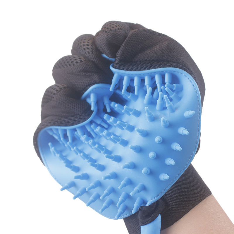 Hand wearing black mesh glove holding blue silicone pet grooming brush with soft bristles