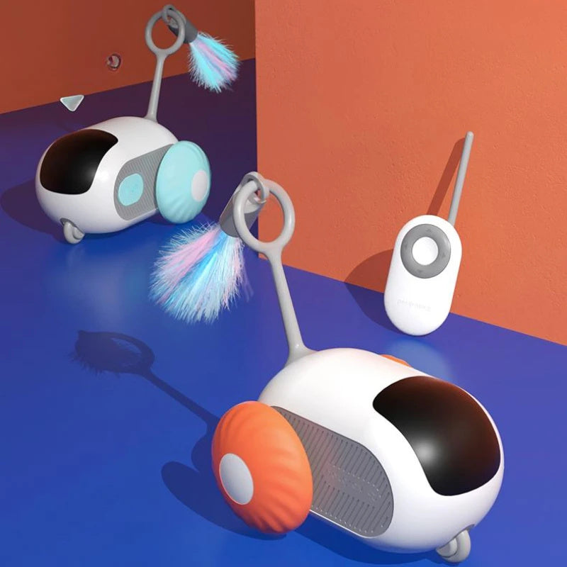 Two remote control cat toys with feather attachments and colorful wheels on blue surface near orange wall