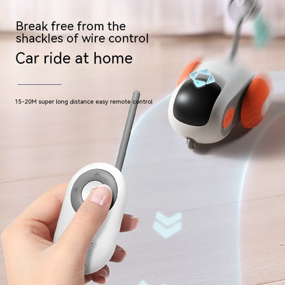 Hand holding white remote control for blue and orange pet interactive car toy on wooden floor