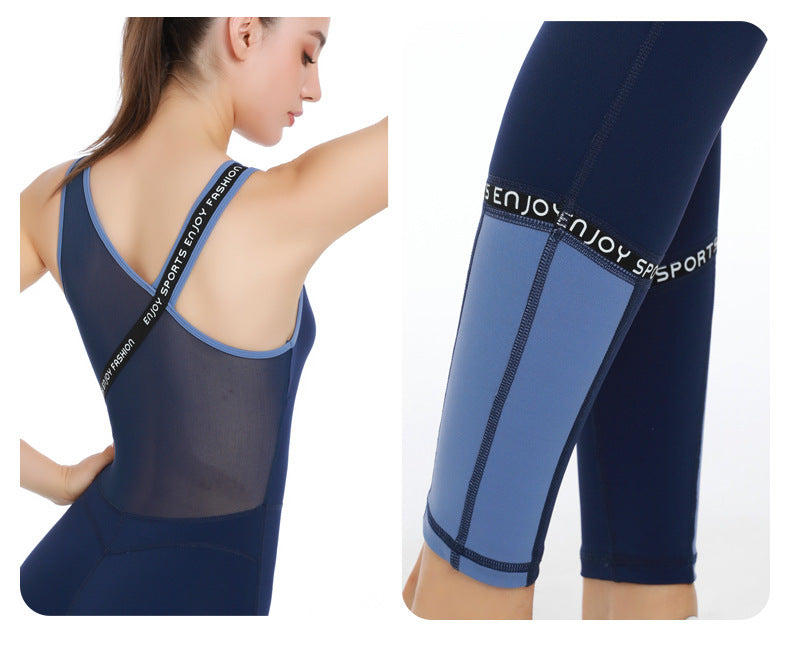 Woman wearing navy blue and light blue yoga bodysuit with mesh back and sporty ENJOY strap detail