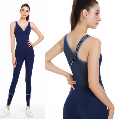 Woman wearing navy blue yoga bodysuit with mesh back and slogan straps, white sneakers, studio background