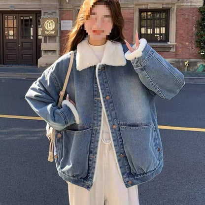 Woman wearing oversized blue denim jacket with white faux fur collar and cuffs outdoors