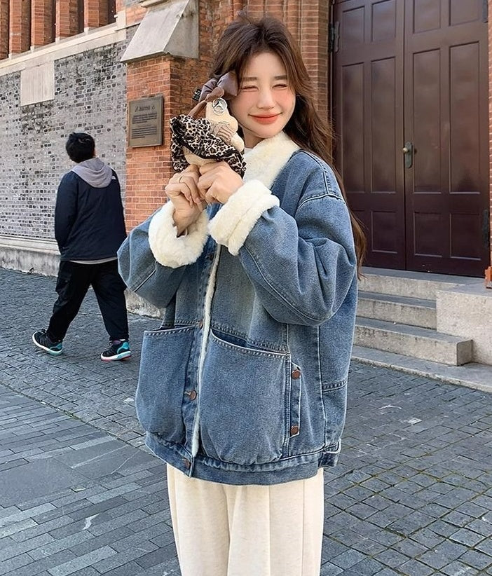 Young woman smiling wearing blue denim jacket with white fur lining outdoors on cobblestone street