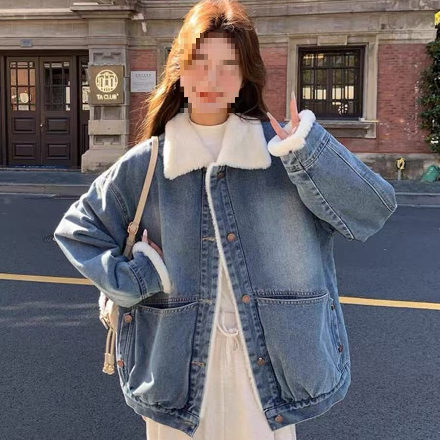 Woman wearing oversized blue denim jacket with white faux fur collar and cuffs outdoors
